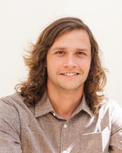Alex Myrin, photographed outdoors against a pale wall.